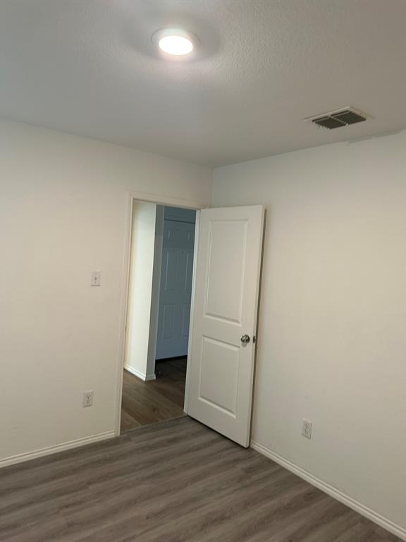 5906 Nyquist Way Forney, TX 75126 - Photo 9 of 27 Empty room featuring wood finished floors and a textured ceiling