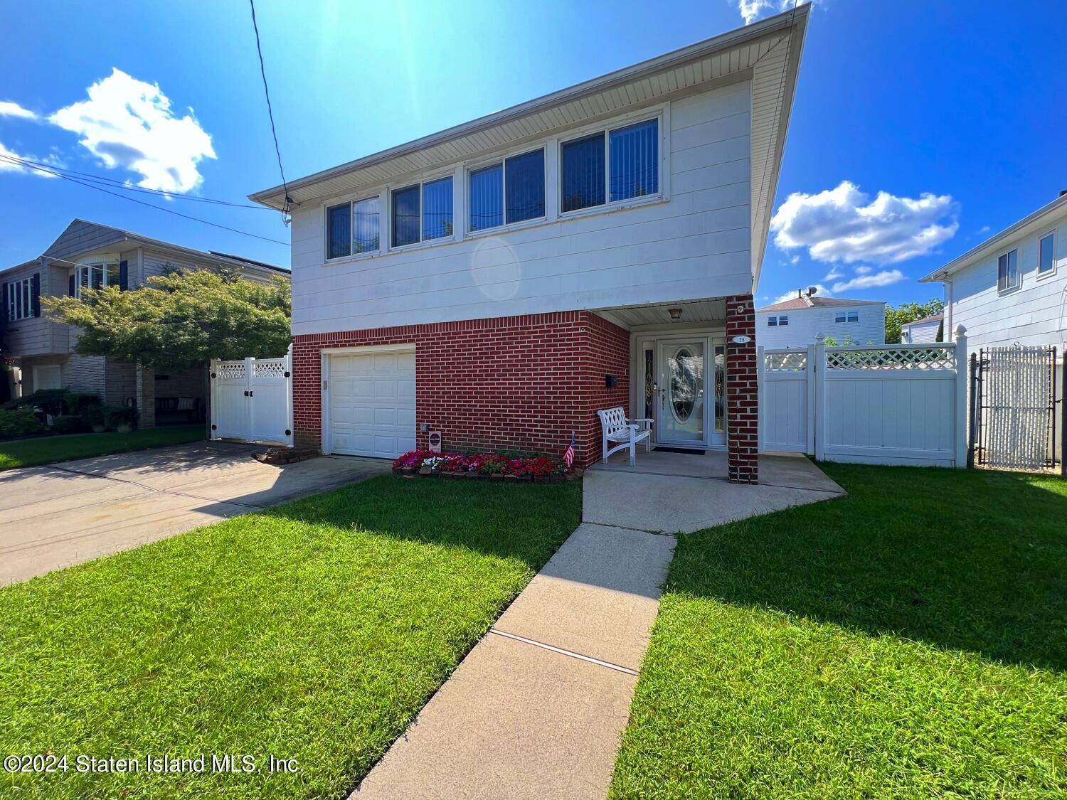 28 Gary Place Staten Island, NY 10314 - Photo 1 of 28 a front view of a house with a yard and a garage