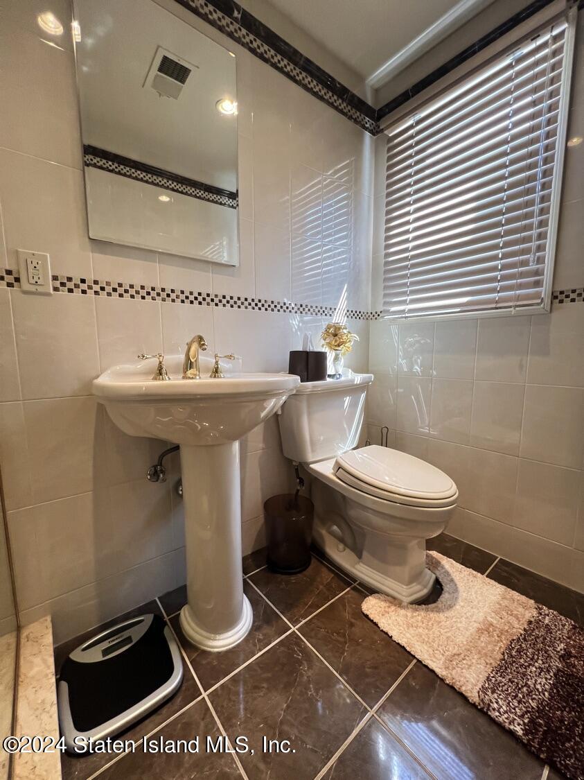 28 Gary Place Staten Island, NY 10314 - Photo 16 of 28 a bathroom with a toilet a sink and mirror