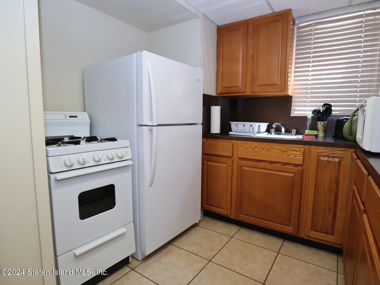 28 Gary Place Staten Island, NY 10314 - Photo 18 of 28 a kitchen with a stove a refrigerator and a sink