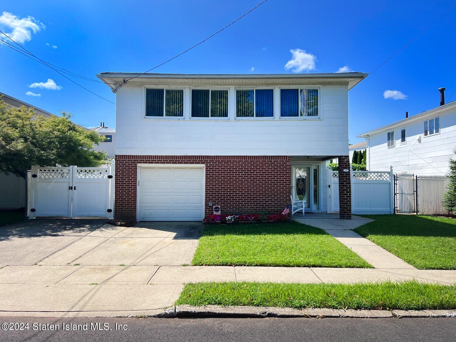 28 Gary Place Staten Island, NY 10314 - Photo 2 of 28 a front view of a house with a yard and garage