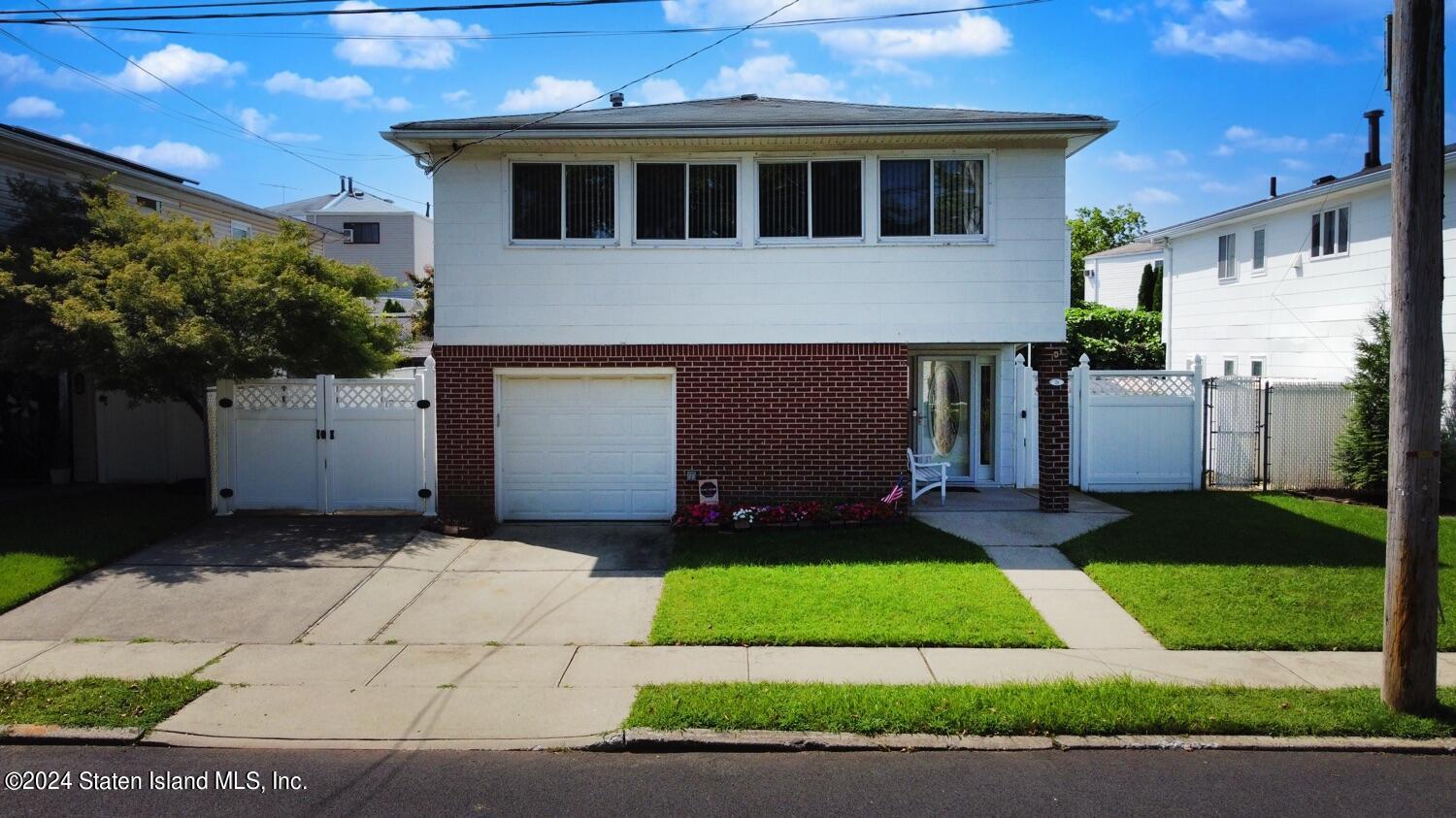 28 Gary Place Staten Island, NY 10314 - Photo 27 of 28 a front view of a house with a yard and garage