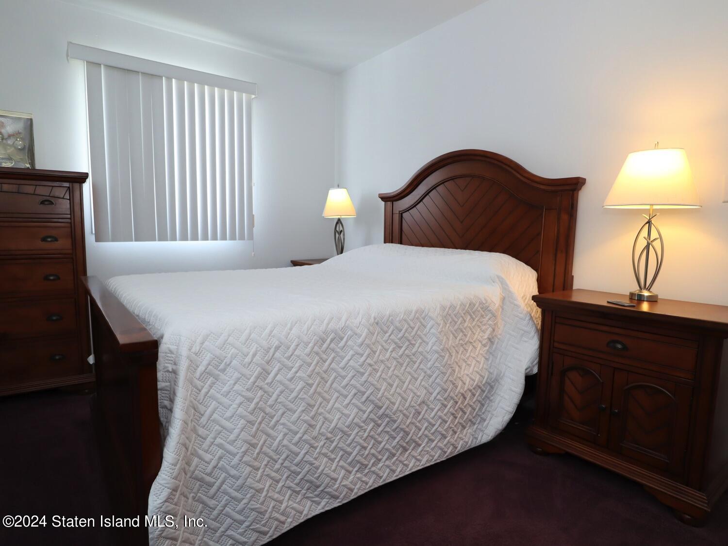 28 Gary Place Staten Island, NY 10314 - Photo 9 of 28 a bedroom with a bed and a lamp