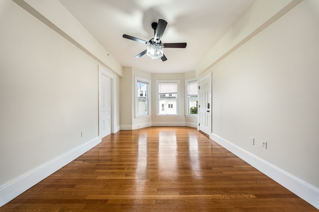 180 Jackson Street, Unit B Lawrence, MA 01841 - Photo 2 of 8 a view of an empty room with window and wooden floor