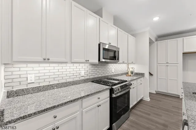 a kitchen with stainless steel appliances granite countertop a sink stove and cabinets