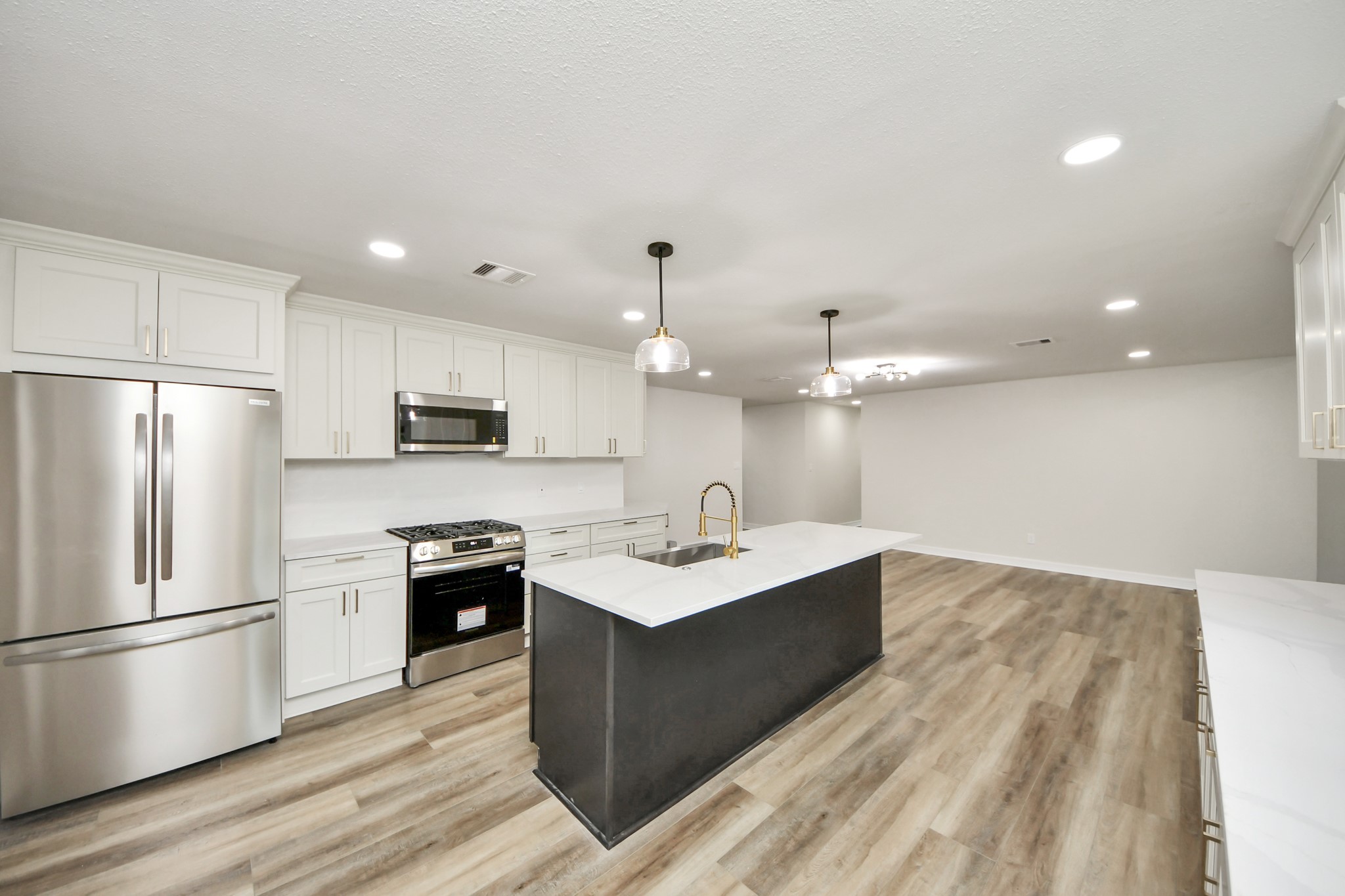 4311 Goldfinch Street Houston, TX 77035 - Photo 15 of 40 a kitchen with stainless steel appliances granite countertop a sink stove a refrigerator and island with wooden floor