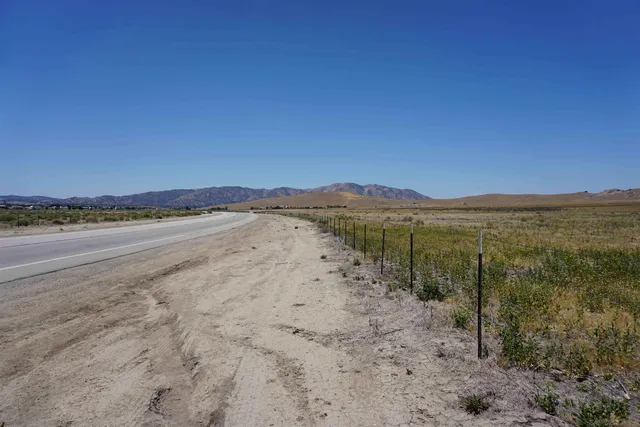 a view of a field with a mountain in the background