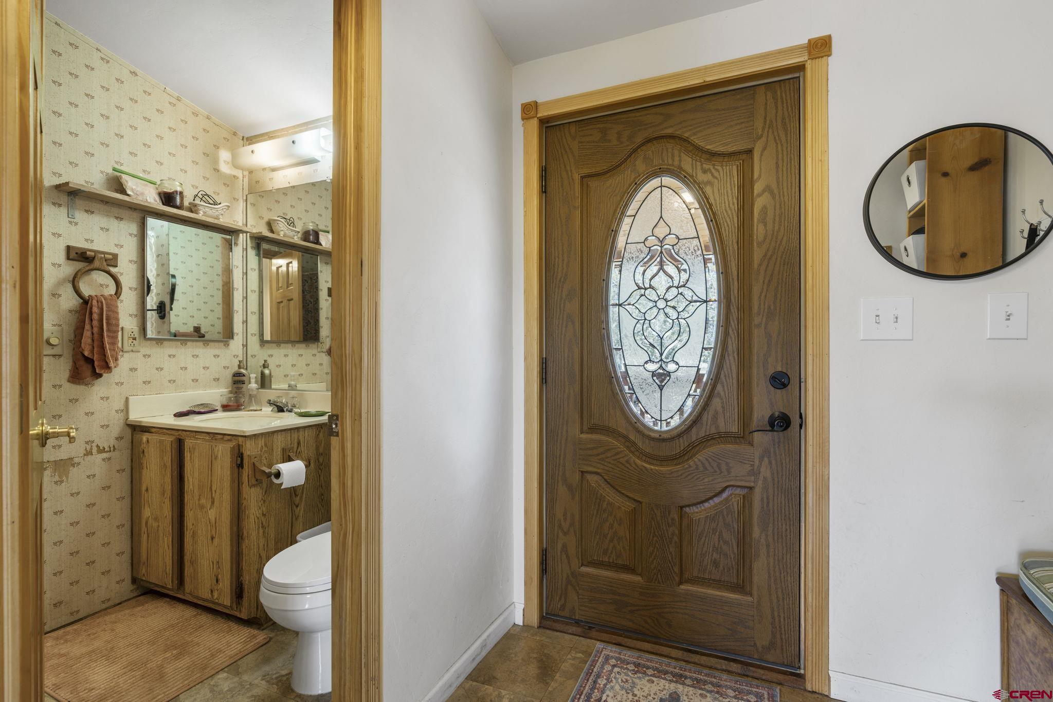 45 Pine Ridge Road Durango, CO 81301 - Photo 18 of 44 a bathroom with a granite countertop toilet a sink and a mirror