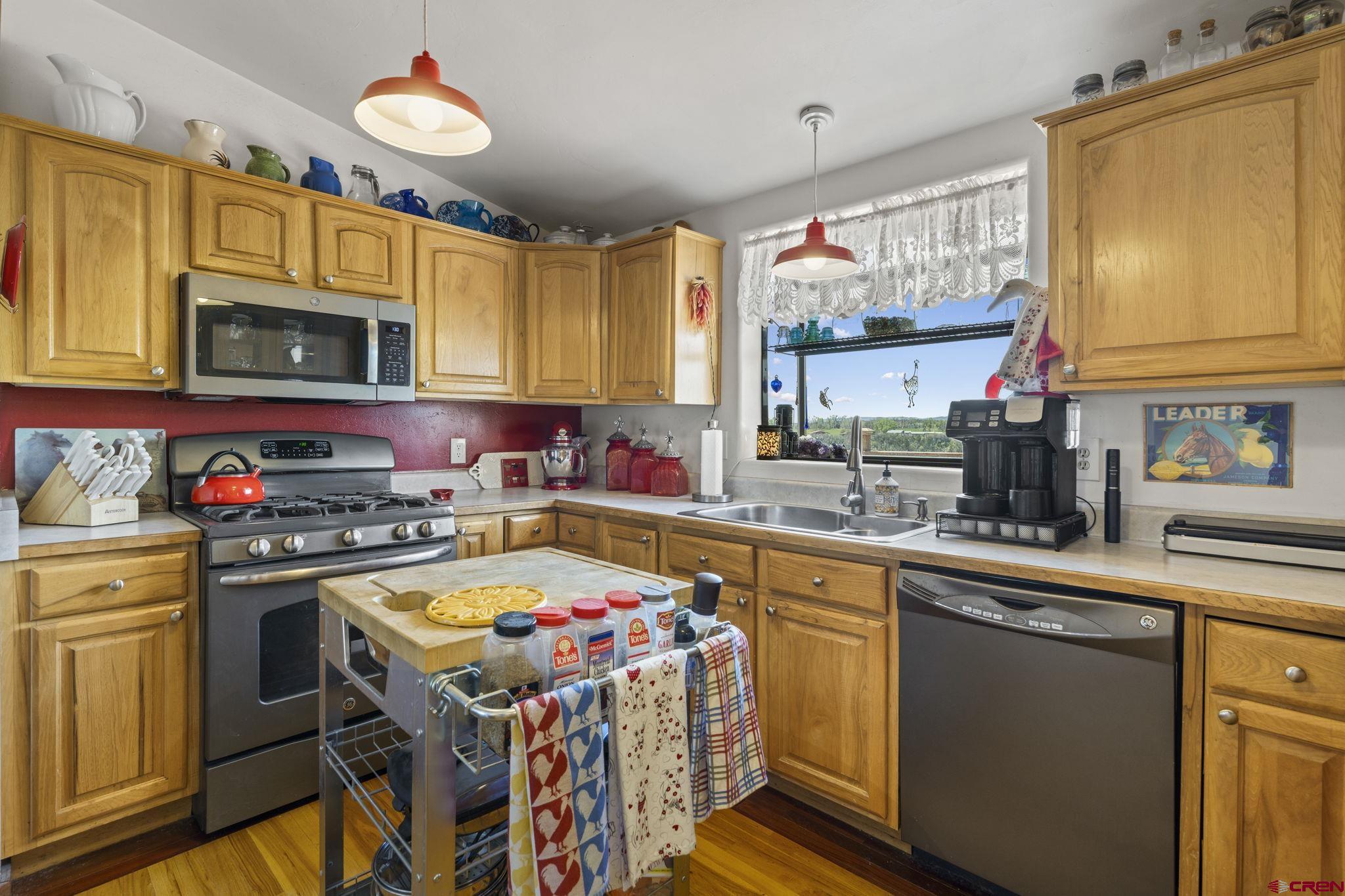 45 Pine Ridge Road Durango, CO 81301 - Photo 6 of 44 a kitchen with a stove a sink dishwasher and white cabinets with wooden floor