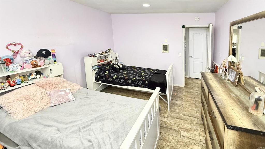 10235 Madrid Way, Unit 114 Spring Valley, CA 91977 - Photo 12 of 26 a bedroom with a bed and a wooden floor