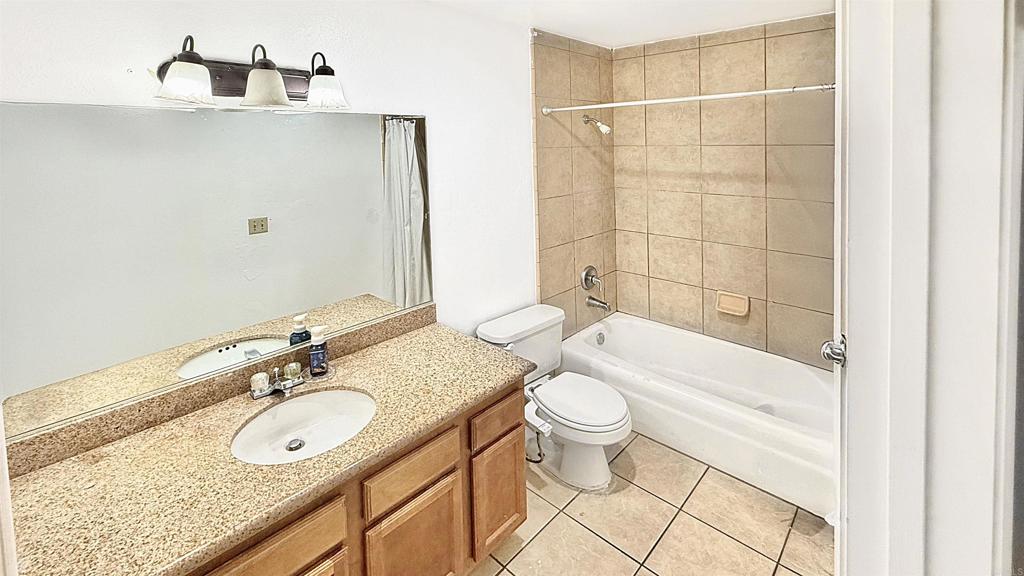 10235 Madrid Way, Unit 114 Spring Valley, CA 91977 - Photo 13 of 26 a bathroom with a granite countertop sink a toilet and bathtub