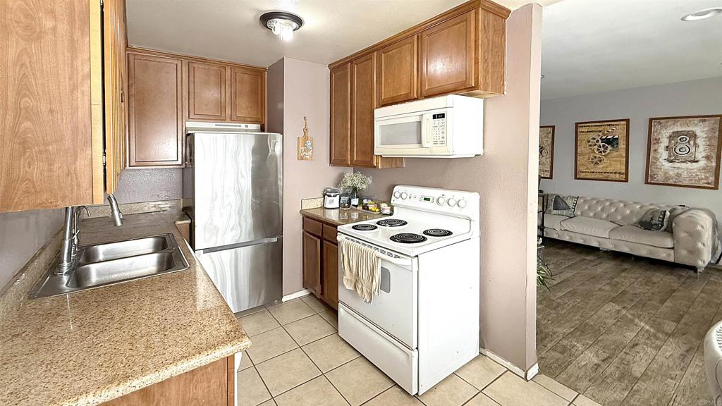 10235 Madrid Way, Unit 114 Spring Valley, CA 91977 - Photo 7 of 26 a kitchen with a refrigerator sink stove and cabinets