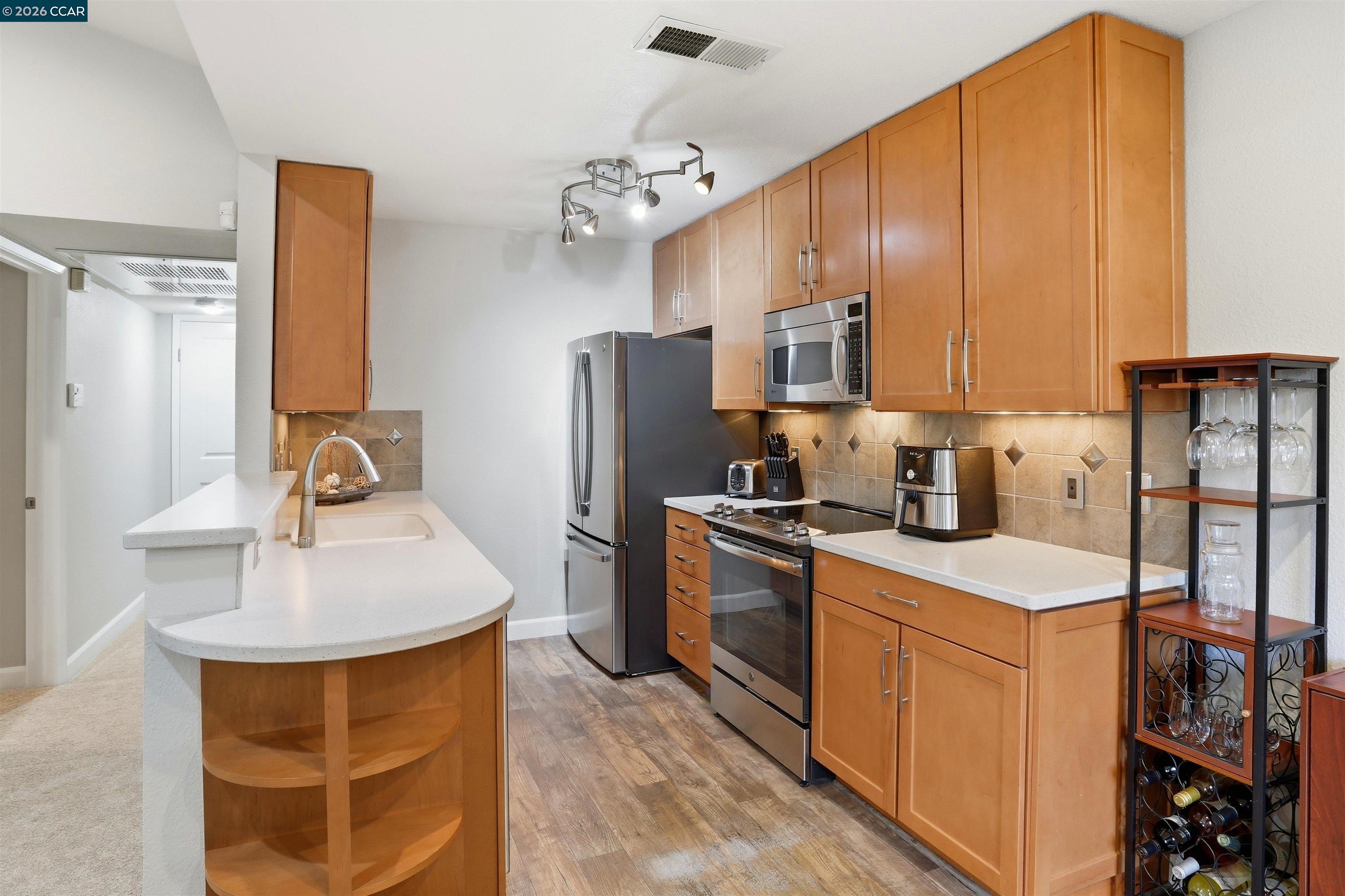7020 Stagecoach Road, Unit G Dublin, CA 94568 - Photo 16 of 21 a kitchen with stainless steel appliances granite countertop a sink stove and refrigerator