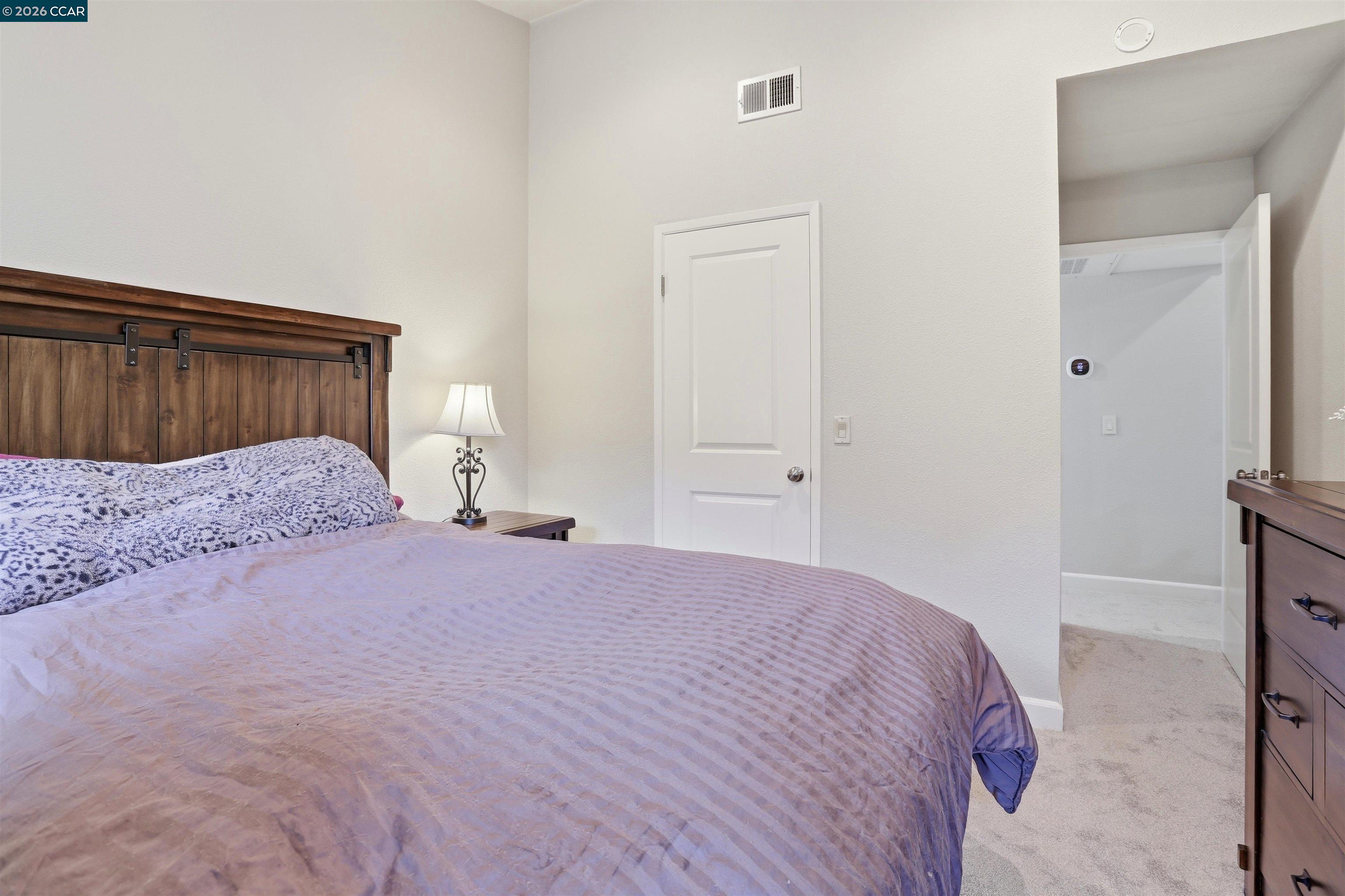 7020 Stagecoach Road, Unit G Dublin, CA 94568 - Photo 17 of 21 a bedroom with a bed and a mirror