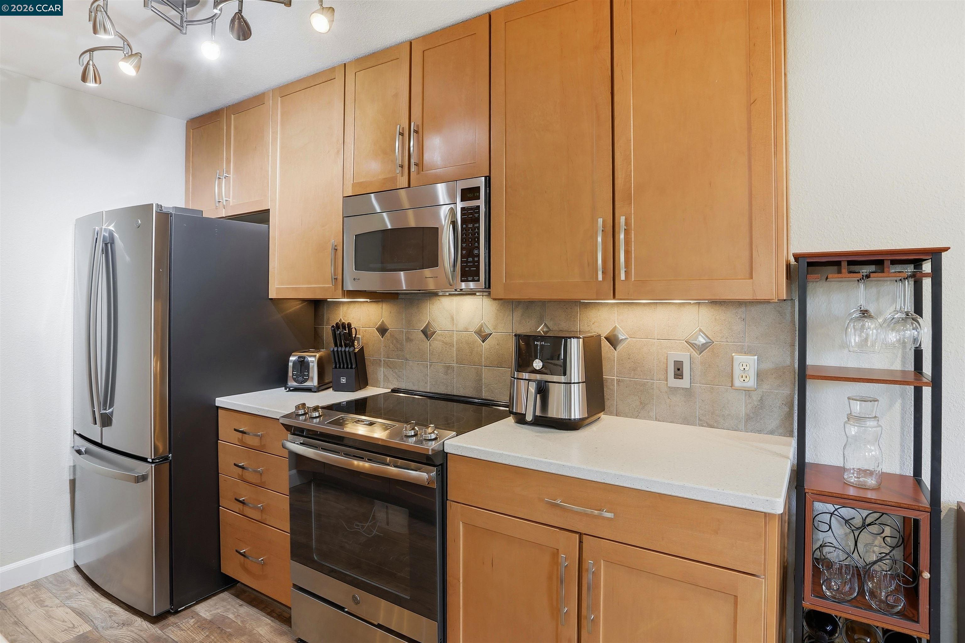 7020 Stagecoach Road, Unit G Dublin, CA 94568 - Photo 6 of 21 a kitchen with stainless steel appliances granite countertop a refrigerator stove and microwave