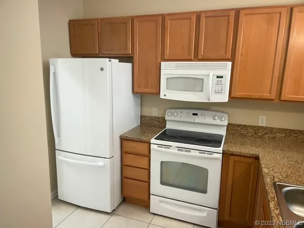 a kitchen with a sink a refrigerator and cabinets