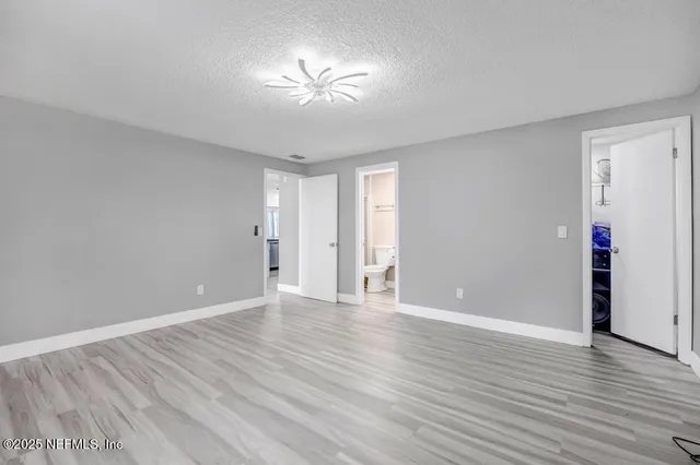 a view of an empty room with wooden floor