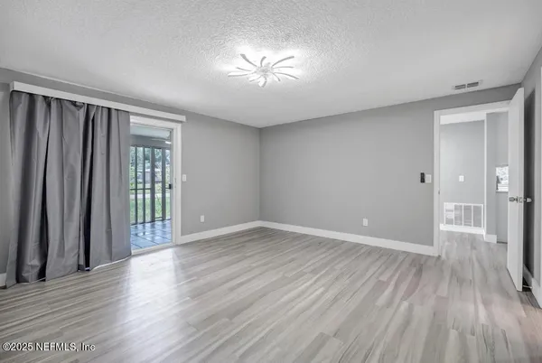 an empty room with wooden floor and a window
