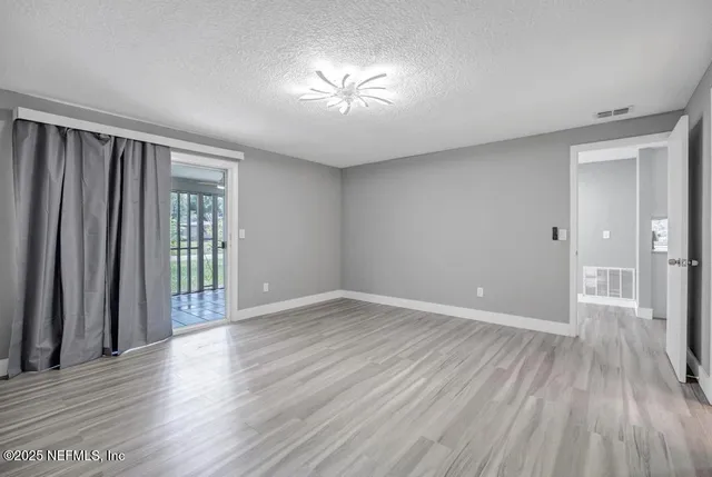 an empty room with wooden floor and a window