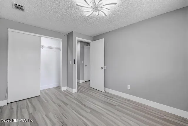wooden floor in an empty room with a fan