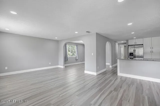 a view of a big room with wooden floor and windows