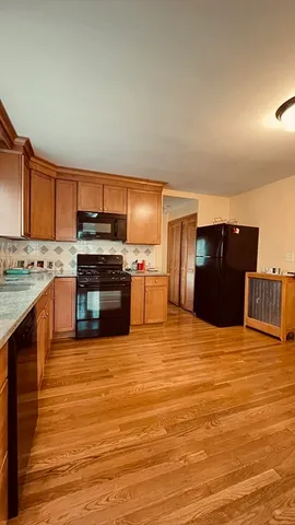 a kitchen with stainless steel appliances kitchen island granite countertop a stove and a refrigerator