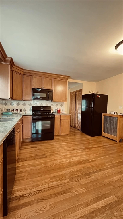 a kitchen with stainless steel appliances kitchen island granite countertop a stove and a refrigerator