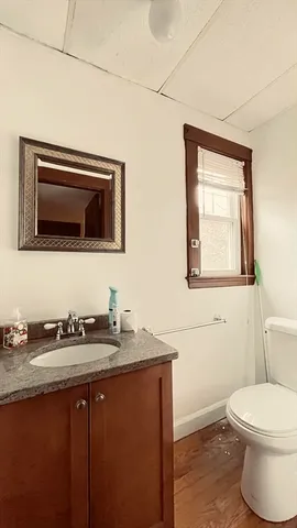 a bathroom with a granite countertop toilet sink and mirror
