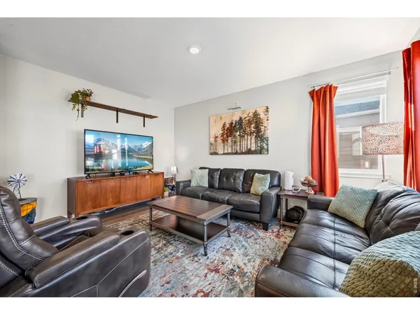 a living room with furniture a rug and a flat screen tv