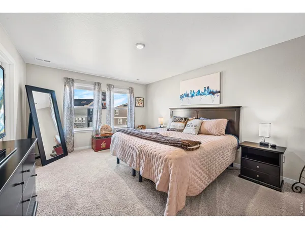 a bedroom with a bed and a flat tv screen on dresser
