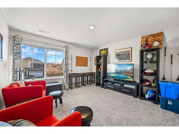 a living room with furniture a flat screen tv and next to a window