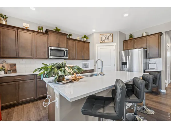 a kitchen with appliances cabinets a sink and a dining table
