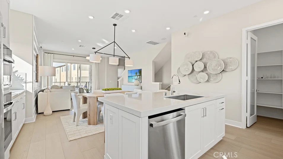 15 Merit Irvine, CA 92618 - Photo 4 of 33 a kitchen that has a lot of cabinets a sink a stove and a wooden floor