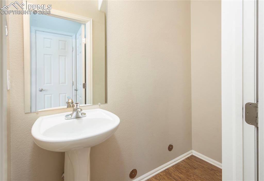 4815 Harrier Ridge Drive Colorado Springs, CO 80916 - Photo 7 of 33 Bathroom featuring dark wood-style flooring and baseboards