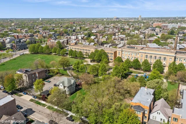 an aerial view of residential houses with outdoor space and trees