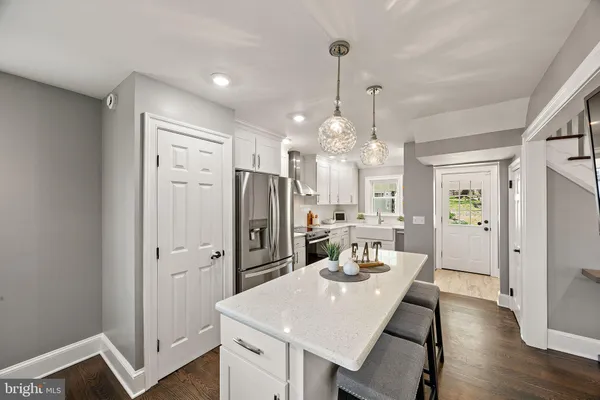a kitchen with stainless steel appliances a dining table chairs and wooden floor