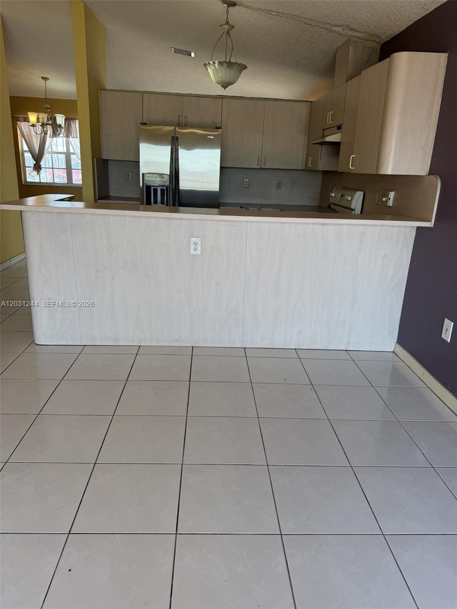 13752 Southwest 156th Street Miami, FL 33177 - Photo 3 of 14 a kitchen with granite countertop a rug a stove a microwave and a counter top space