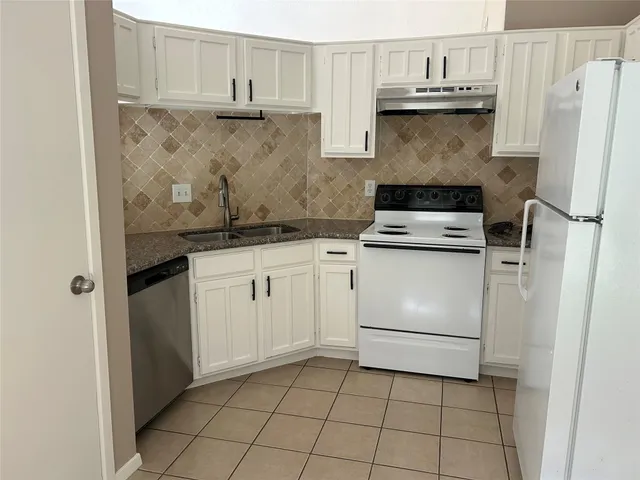 a kitchen with white cabinets and white appliances