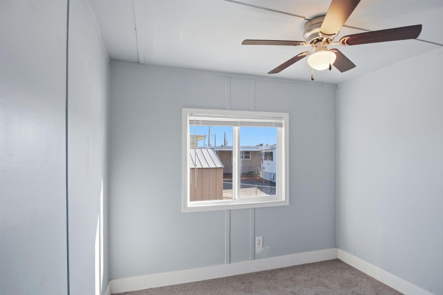 5508 Keith Court, Unit 19 Turlock, CA 95382 - Photo 8 of 13 an empty room with windows and fan