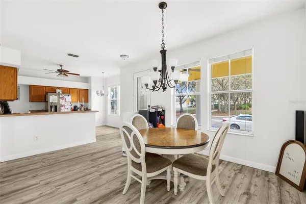 a dining room with furniture a chandelier and wooden floor