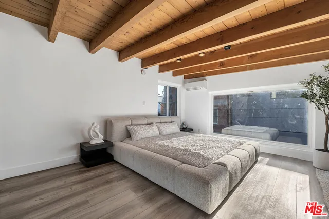 a large bedroom with a bed and wooden floor