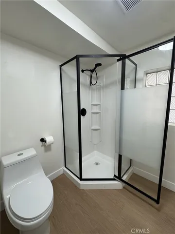 a bathroom with a toilet and a shower