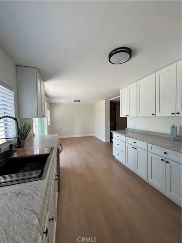 a kitchen with granite countertop a sink a stove top oven and cabinets