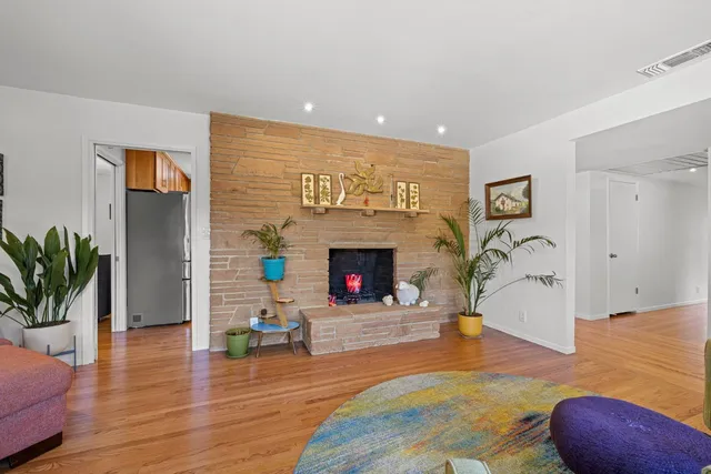 a large kitchen with stainless steel appliances granite countertop a sink dishwasher a stove and a dining table with wooden floor