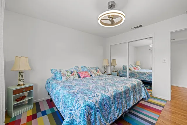 a bedroom with natural light and wooden floor