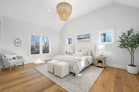 a spacious bedroom with a bed and a potted plant