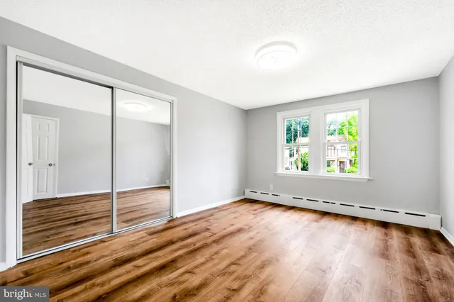 an empty room with wooden floor and window