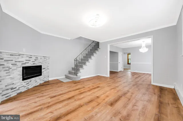 a view of empty room with fireplace and wooden floor