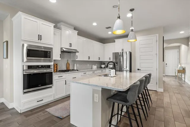 a dining room with furniture a chandelier and wooden floor