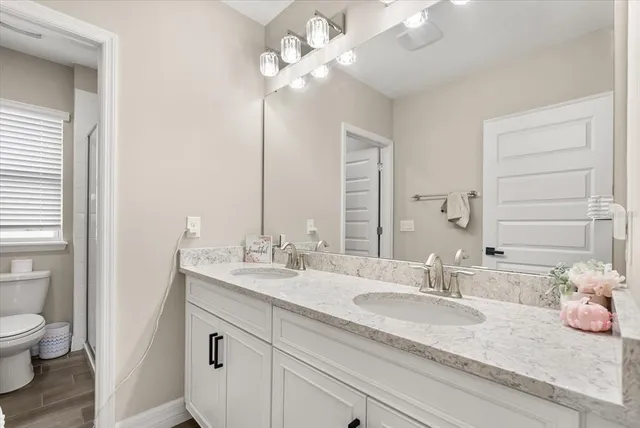 a bathroom with a double vanity sink mirror and shower
